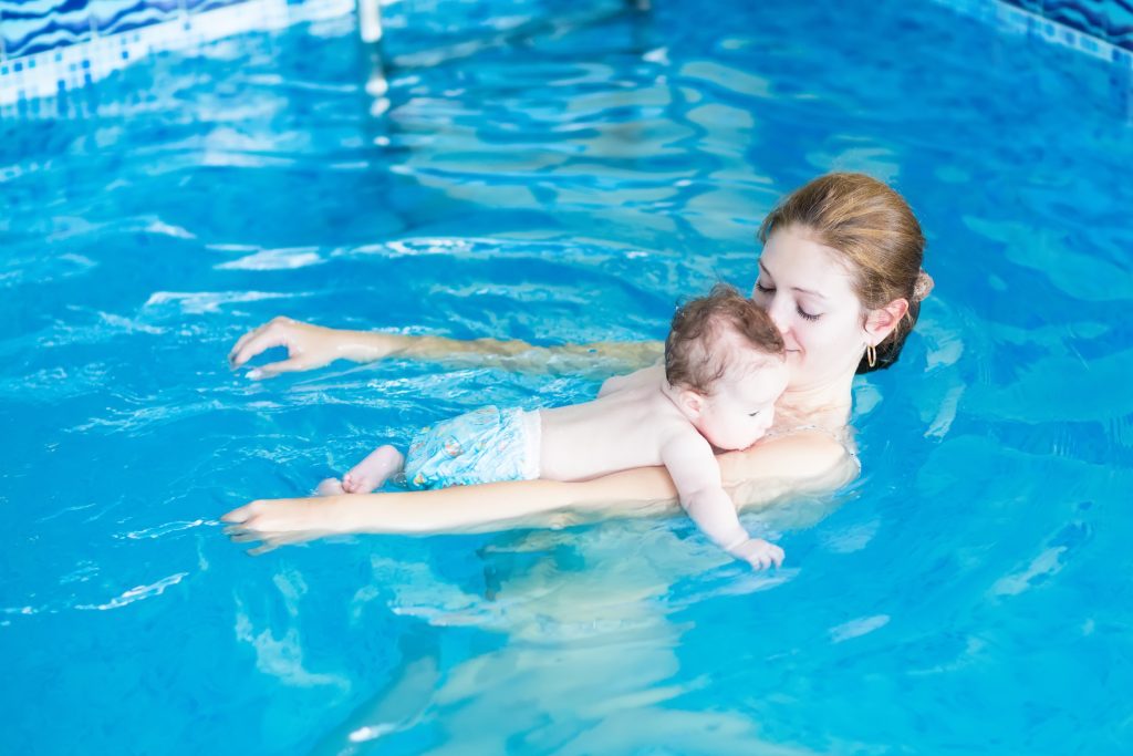 Young mother and her baby relaxing in a swimming pool